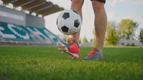 A-man-on-a-football-field-in-slow-motion-in-sports-equipment-bounce-a-soccer-ball